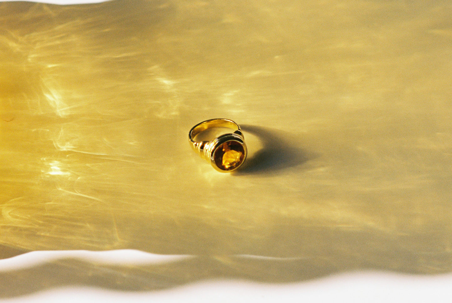 he signet ring style, with its cocktail allure and distinctive ripple ribbing surface detail, sets this piece apart as a true statement of individuality.. shot in a sea of amber light