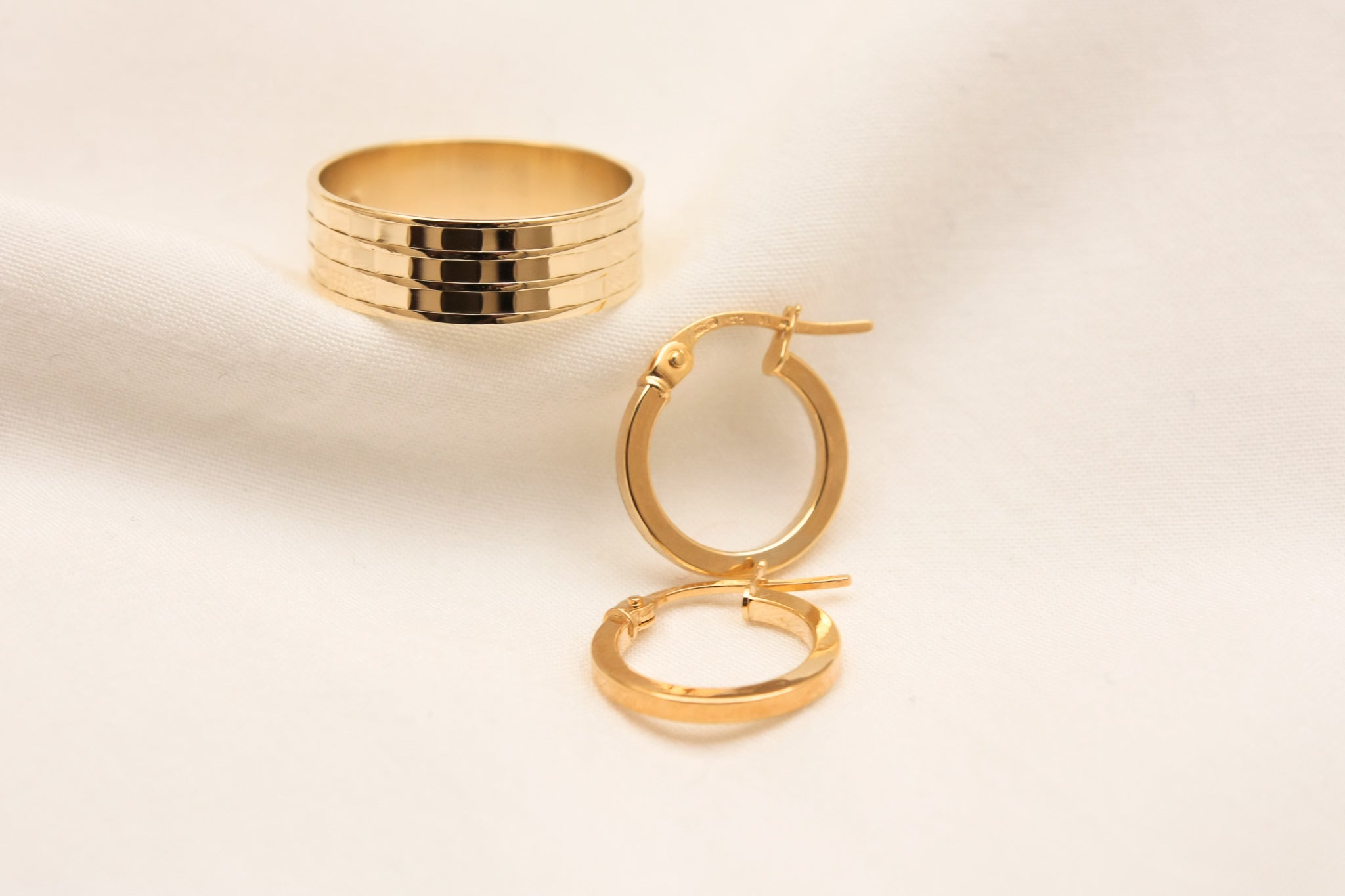 gold ring and gold hoop earrings. wedding band and earrings
