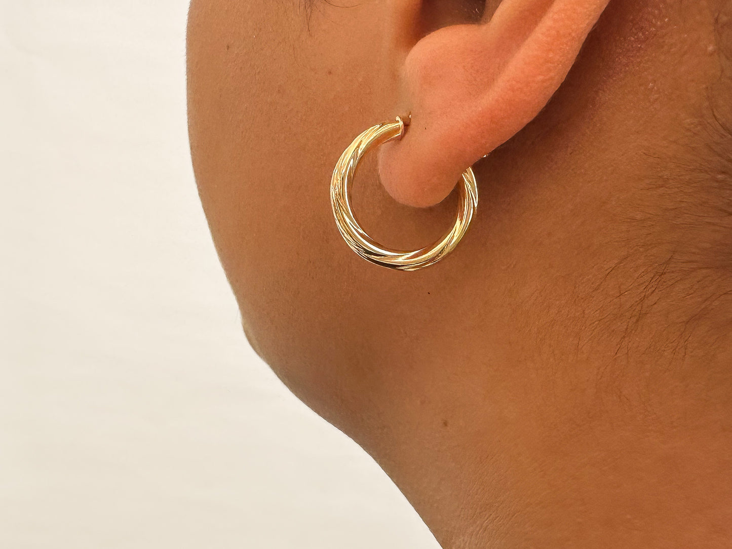  9ct yellow gold, these hoop earrings feature a clasp and twisted tube detail. Their 15mm diameter strikes the perfect balance between subtle and striking. Tubing Options: Choose between the thinner 2.5mm tubing or the thicker 3mm tubing, allowing you to tailor your style to your preferences.