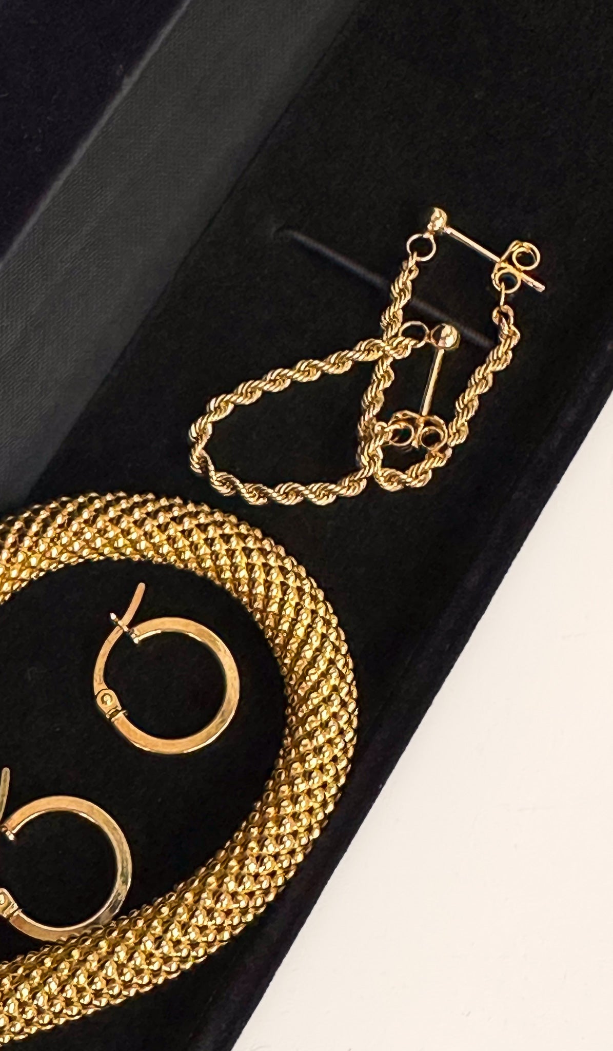 gold jewellery displayed on a velvet jewellery box. Hope earrings, chain earrings and gold bracelet