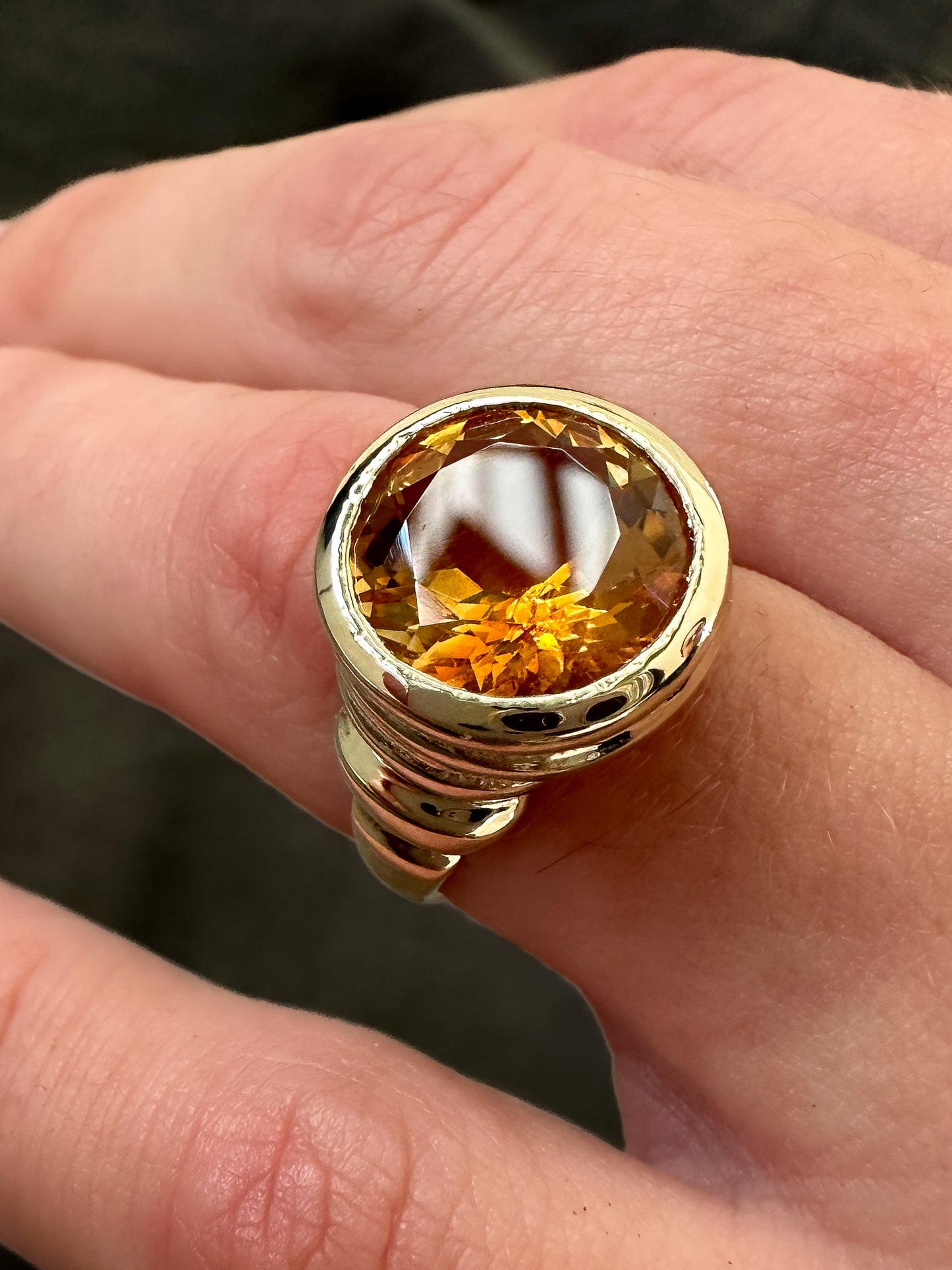 Solid gold cocktail ring with a bright orange citrine gemstone.