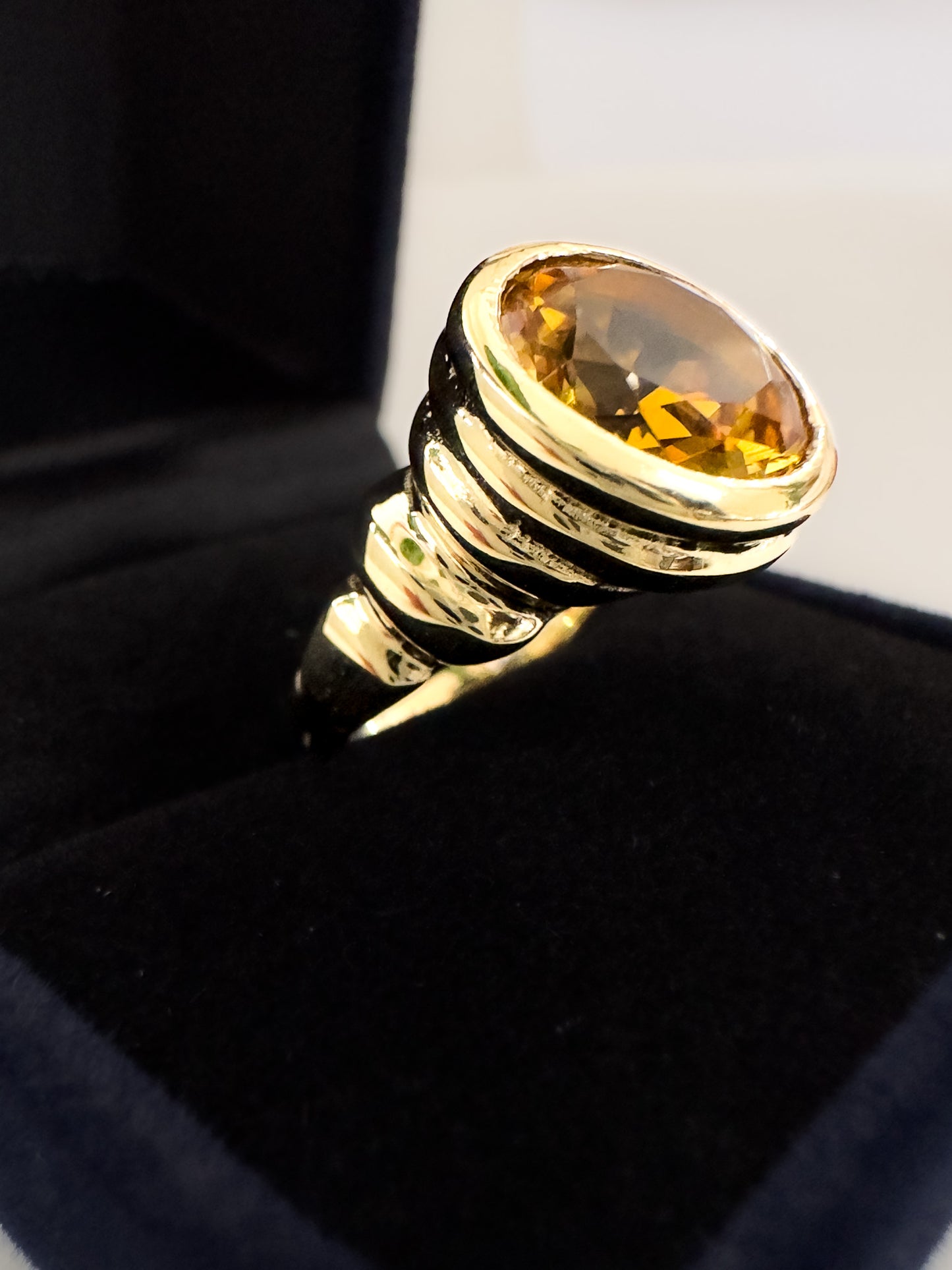 Solid gold cocktail ring with a bright orange citrine gemstone.