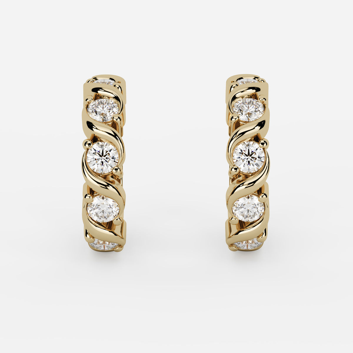 A pair of yellow gold huggie hoop earrings, each featuring a twisted bar set with four round-cut clear gemstones in a prong setting, shown against a light gray background.
