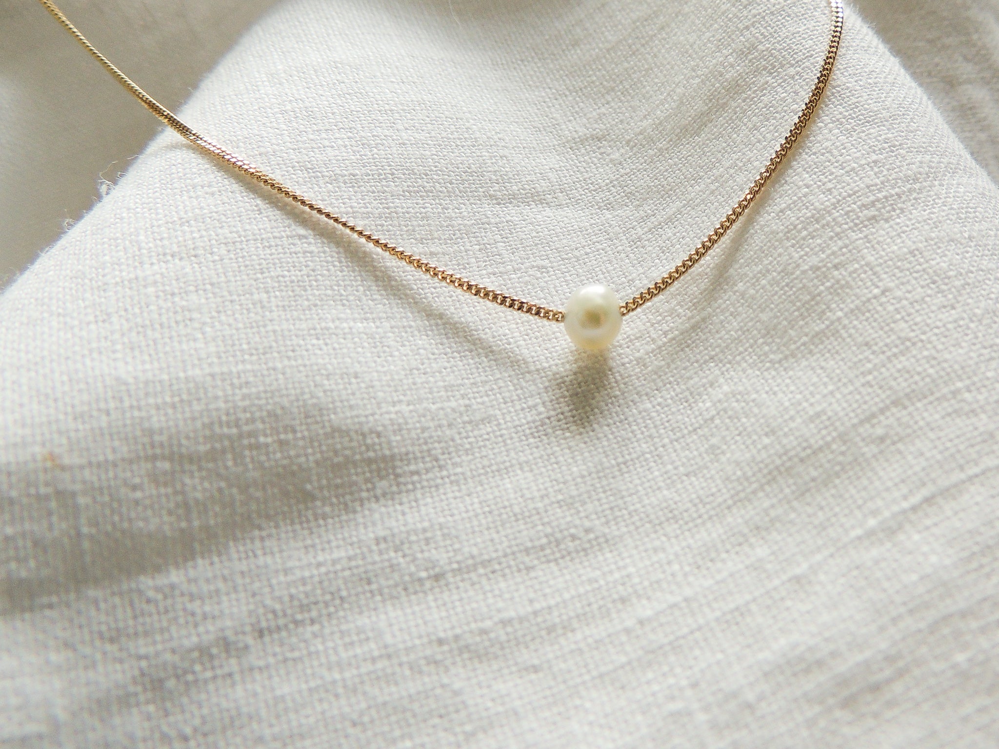 This dainty necklace features an A-grade freshwater pearl gracefully strung on a sterling silver curb chain, creating a classic and timeless look.
