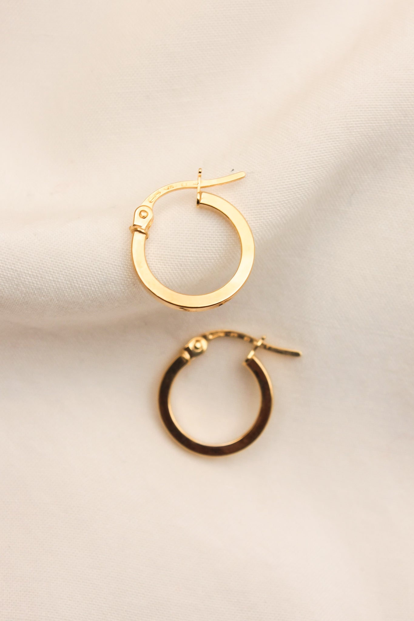 LORNE 9ct Yellow Gold 10mm Hoop Earring—a minimalist's dream of clean lines and reflective surfaces.  Features:  Precious Metal: Crafted from solid 9ct yellow gold with a prominent 375 stamp. Clean and Reflective: Chosen for its clean lines and reflective surfaces, this earring embodies minimalist elegance at its finest.