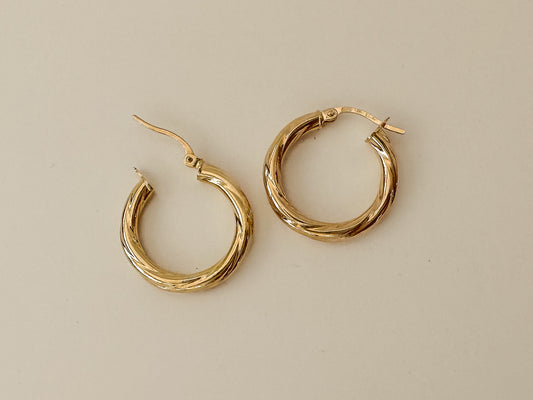  9ct yellow gold, these hoop earrings feature a clasp and twisted tube detail. Their 15mm diameter strikes the perfect balance between subtle and striking. Tubing Options: Choose between the thinner 2.5mm tubing or the thicker 3mm tubing, allowing you to tailor your style to your preferences.