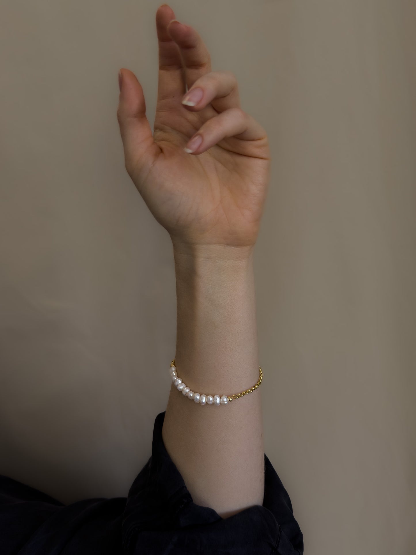pearl bracelet draped elegantly on models wrist. fine jewellery.
