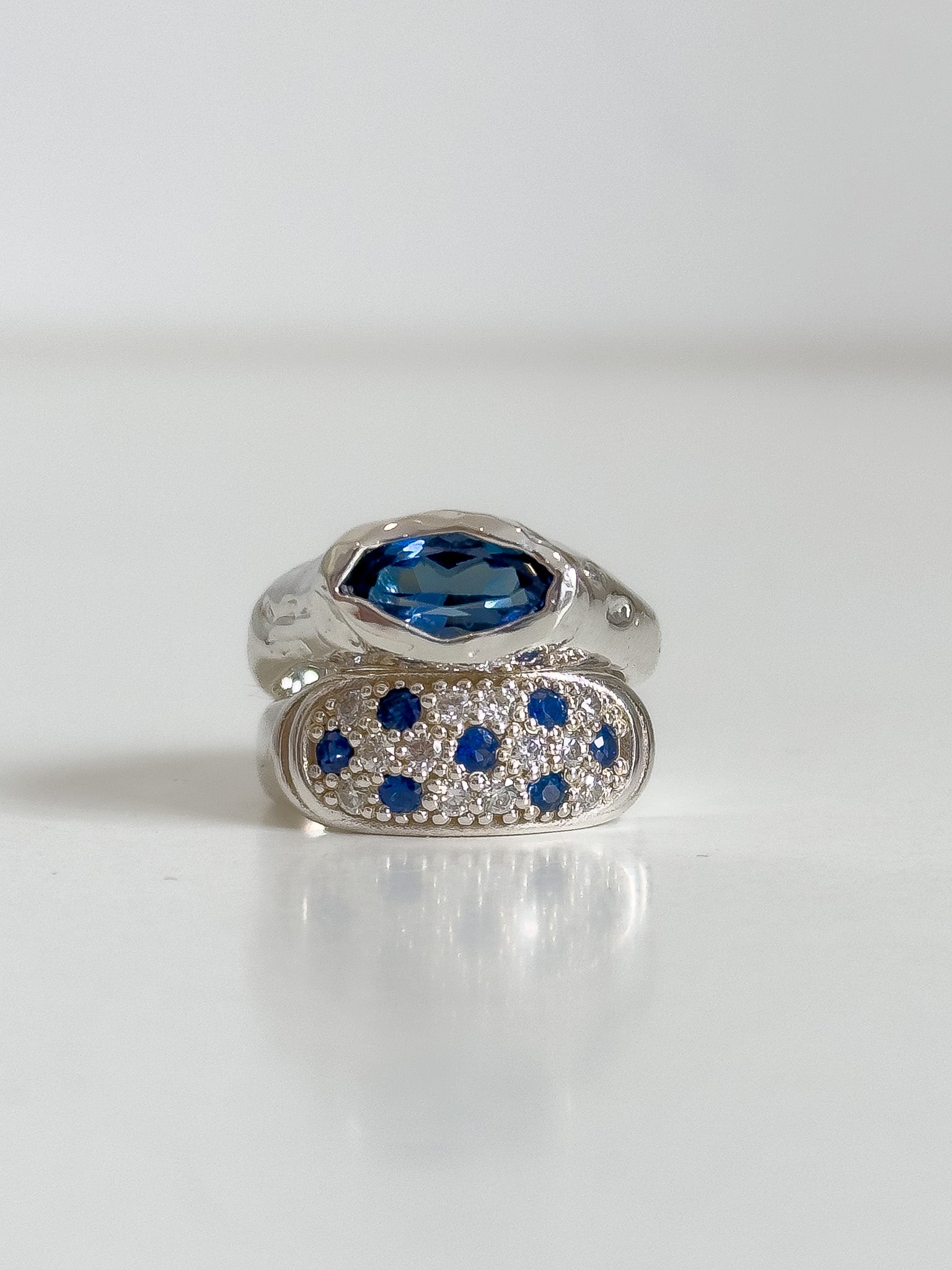 Silver ring with a blue gemstone on a white background