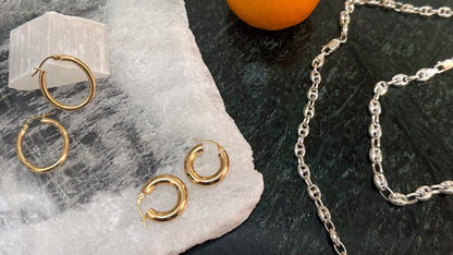 this image show different sides gold hoop earrings and sterling silver Gucci chain and bracelet
