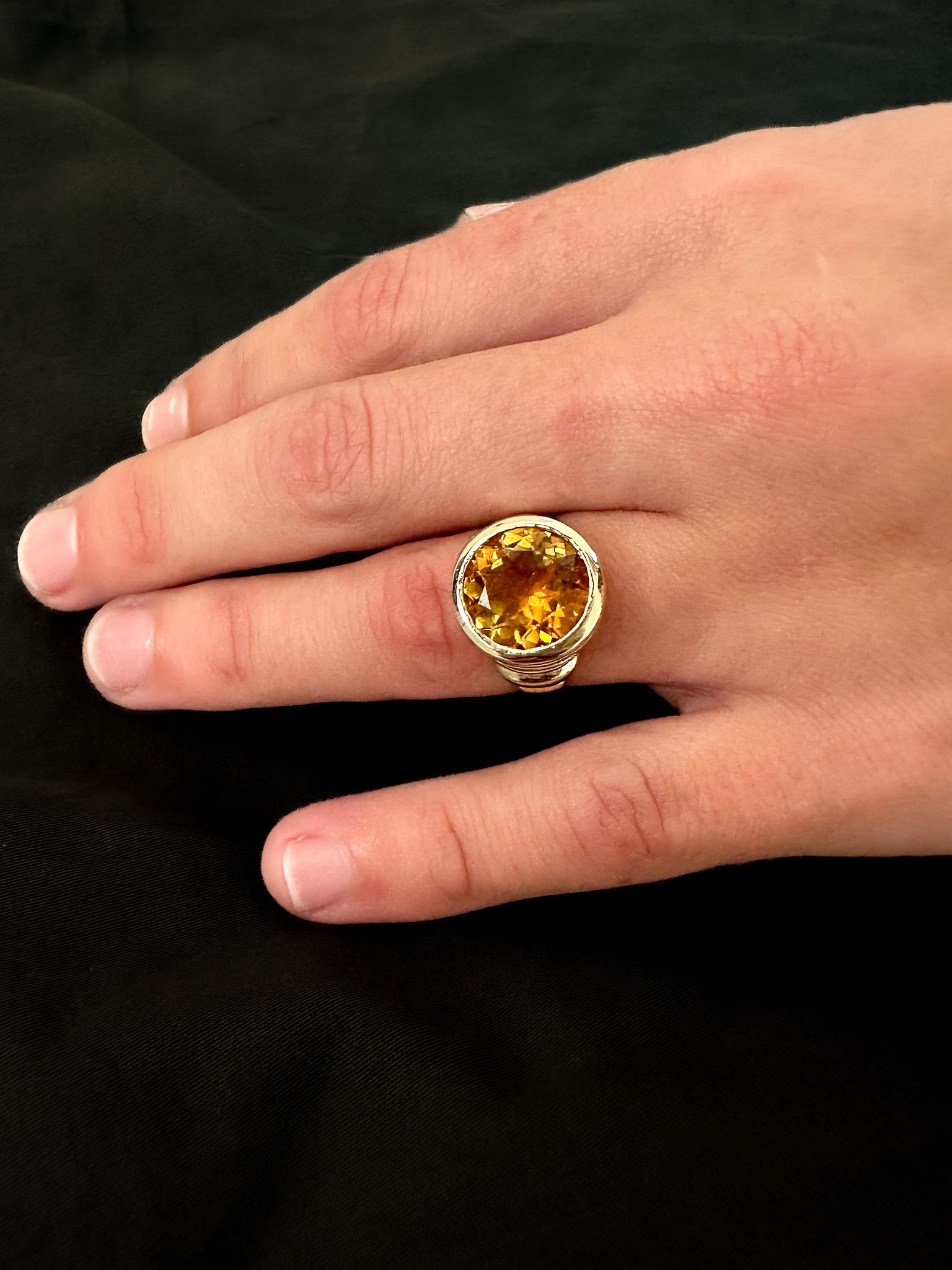 Solid gold cocktail ring with a bright orange citrine gemstone. 