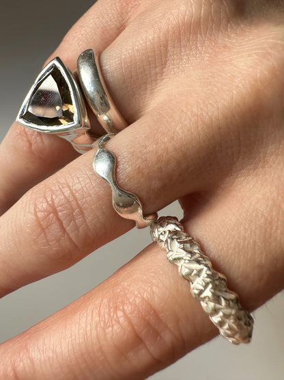 Layers of silver rings on a hand.This ring presents a design that beautifully simulates crinkled and crumpled metal, accentuated by the dramatic interplay of high shine and matte surfaces. It Solid 925 Sterling Silver