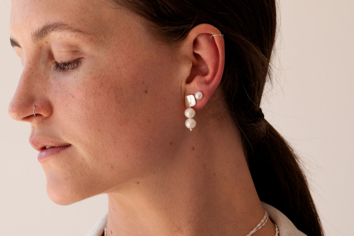 Dangling pearl earrings.  This pair features two 8mm lustrous, high-grade freshwater pearls, each strung on a durable sterling silver chain and securely connected to a sturdy sterling silver base.