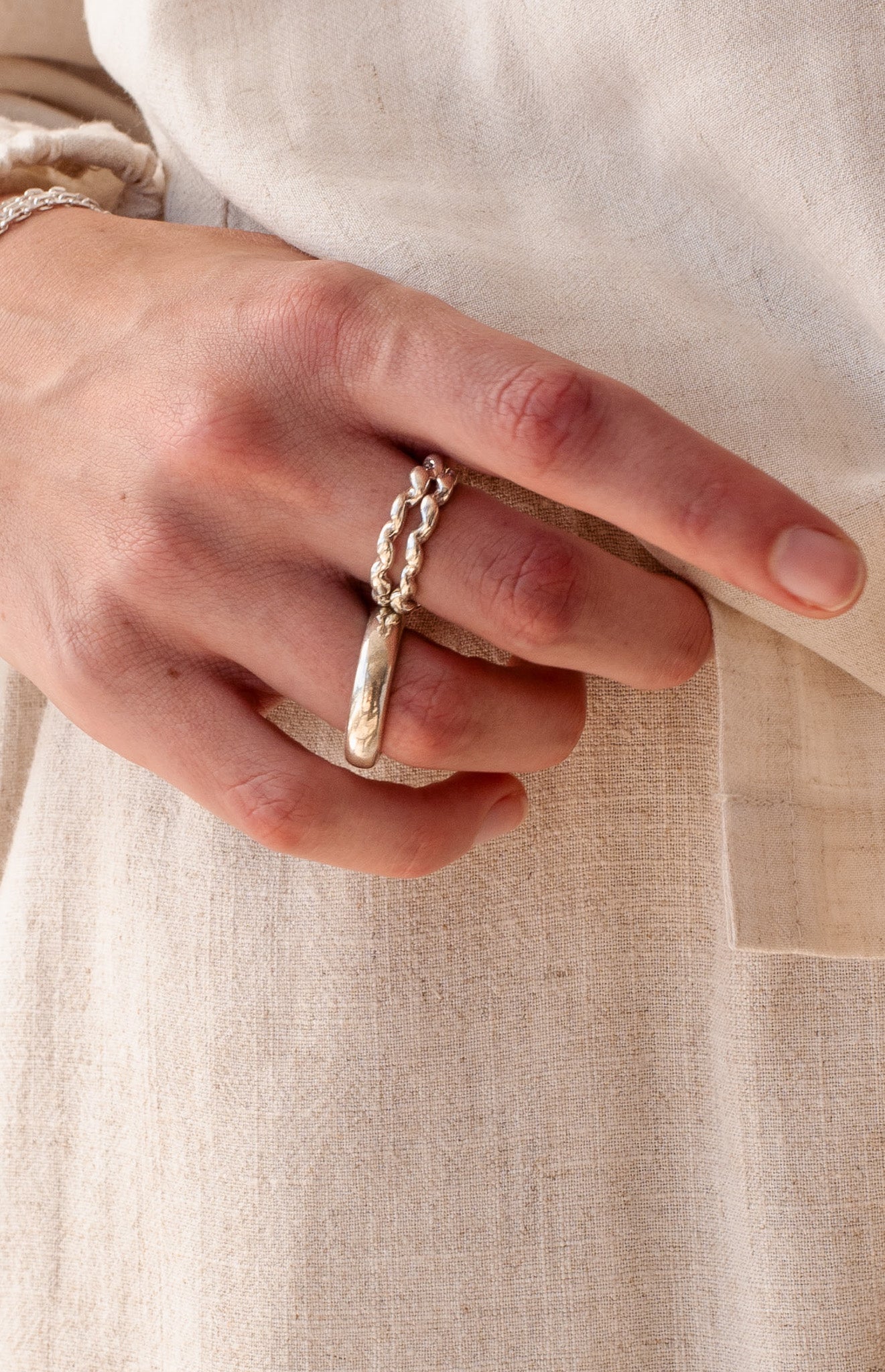 silver rings stacked one hand to form a cohesive look. Playful stacking of rings. Minimalist silver rings.