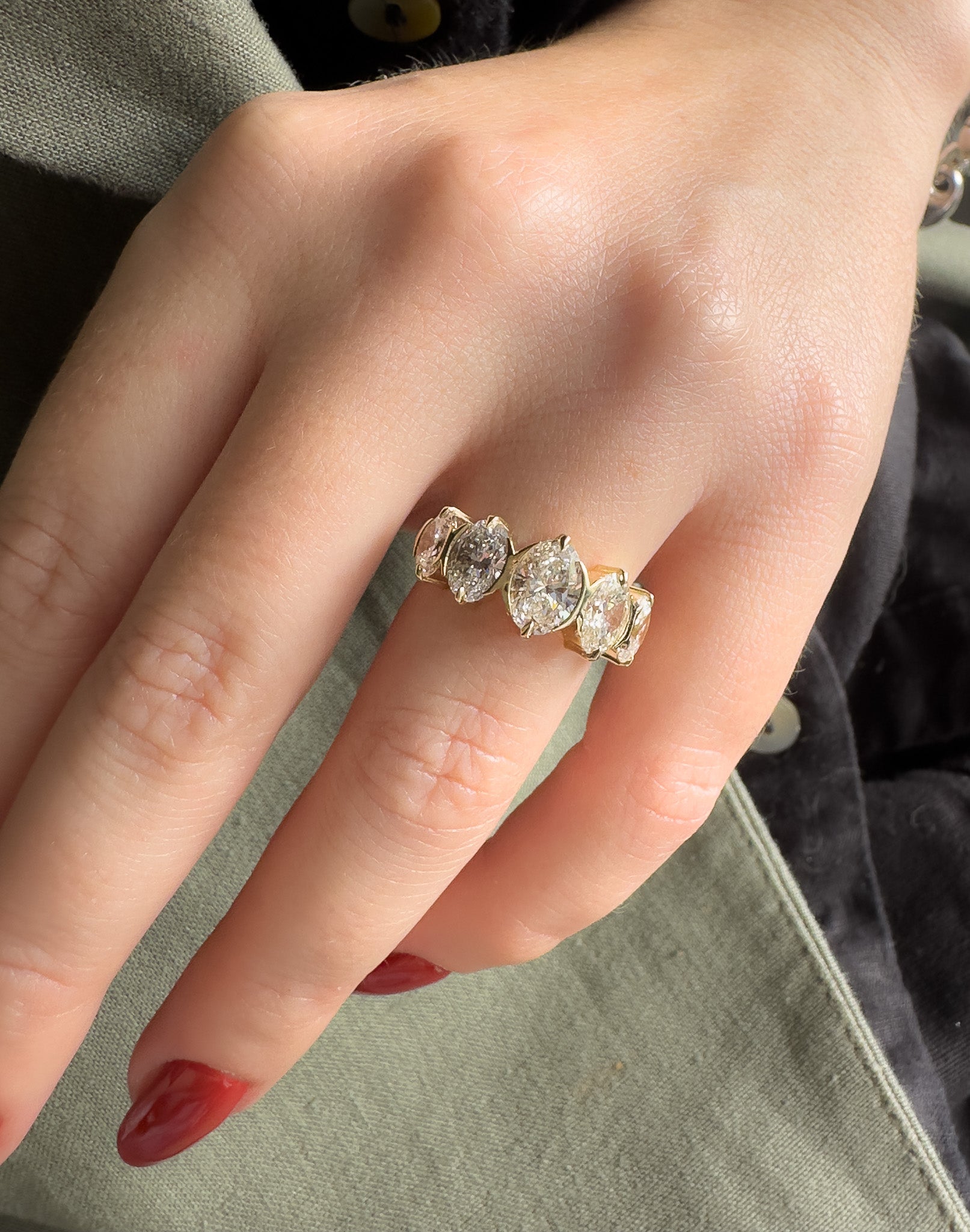 Close-up of a hand wearing a diamond ring with a soft focus background