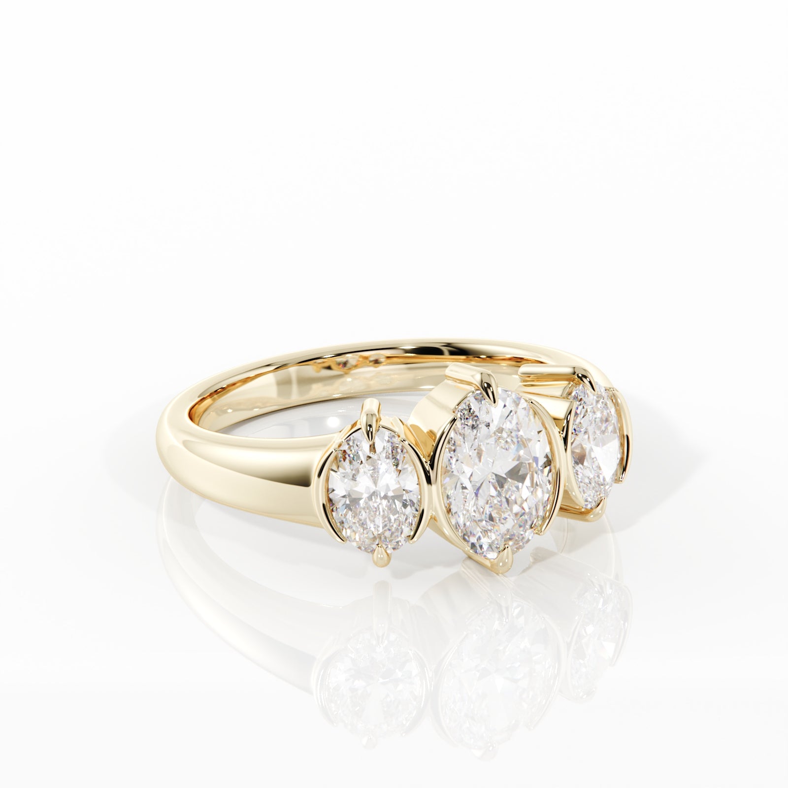 A yellow gold ring featuring three oval-cut clear gemstones in a row, displayed on a clean white reflective surface.