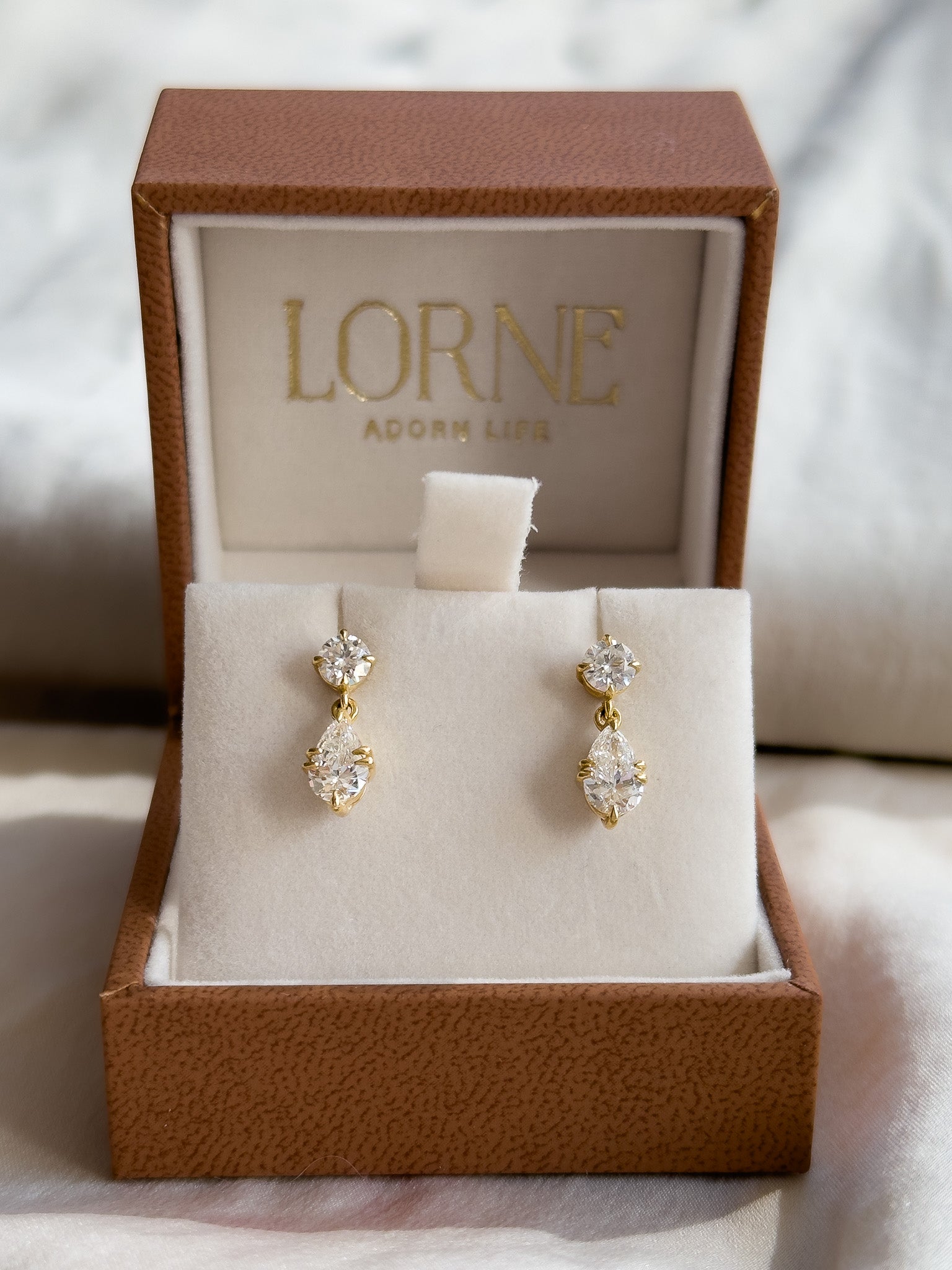 Gold earrings in a LORNE box on a soft background
