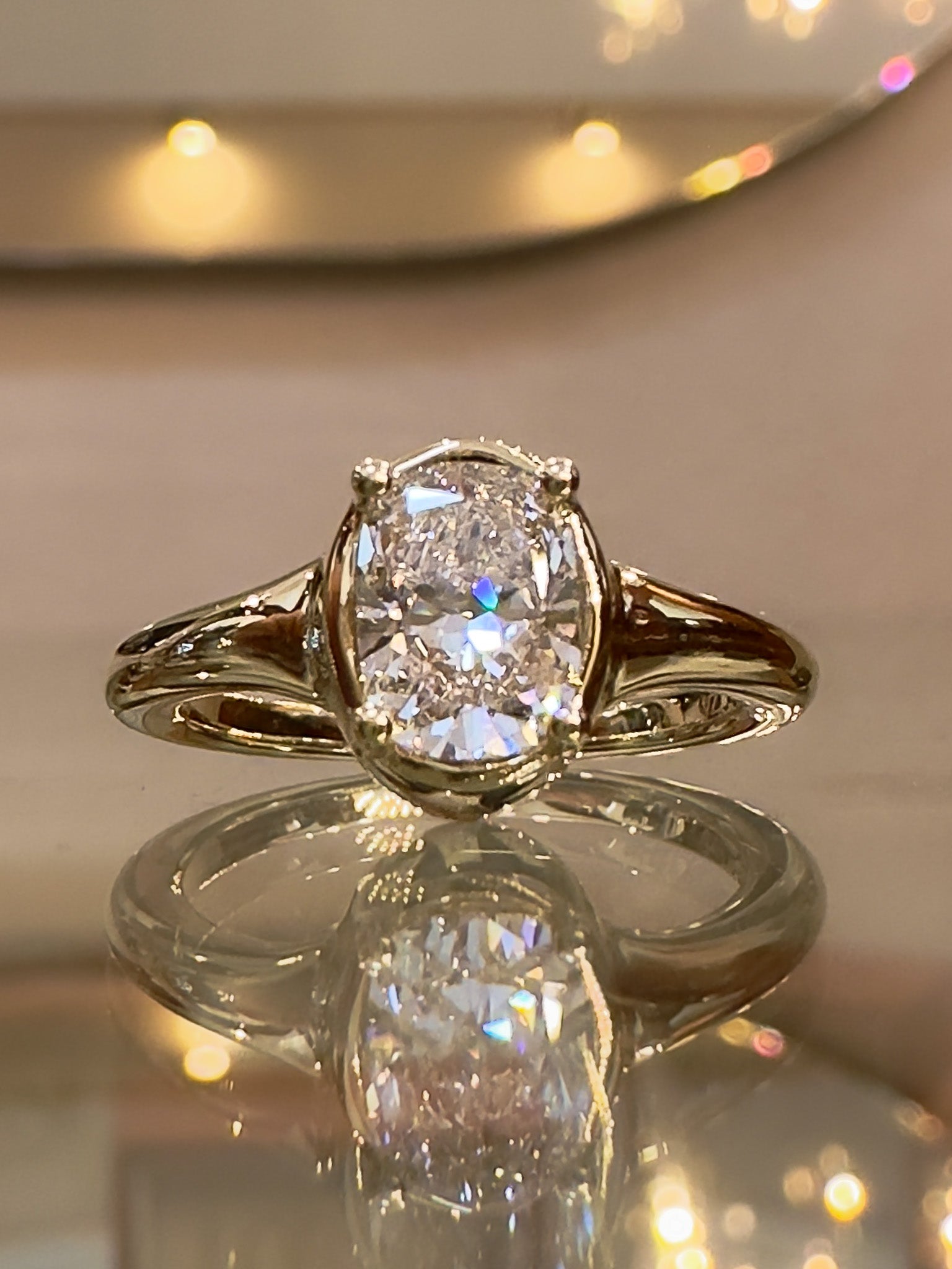 Gold ring with a large diamond on a reflective surface