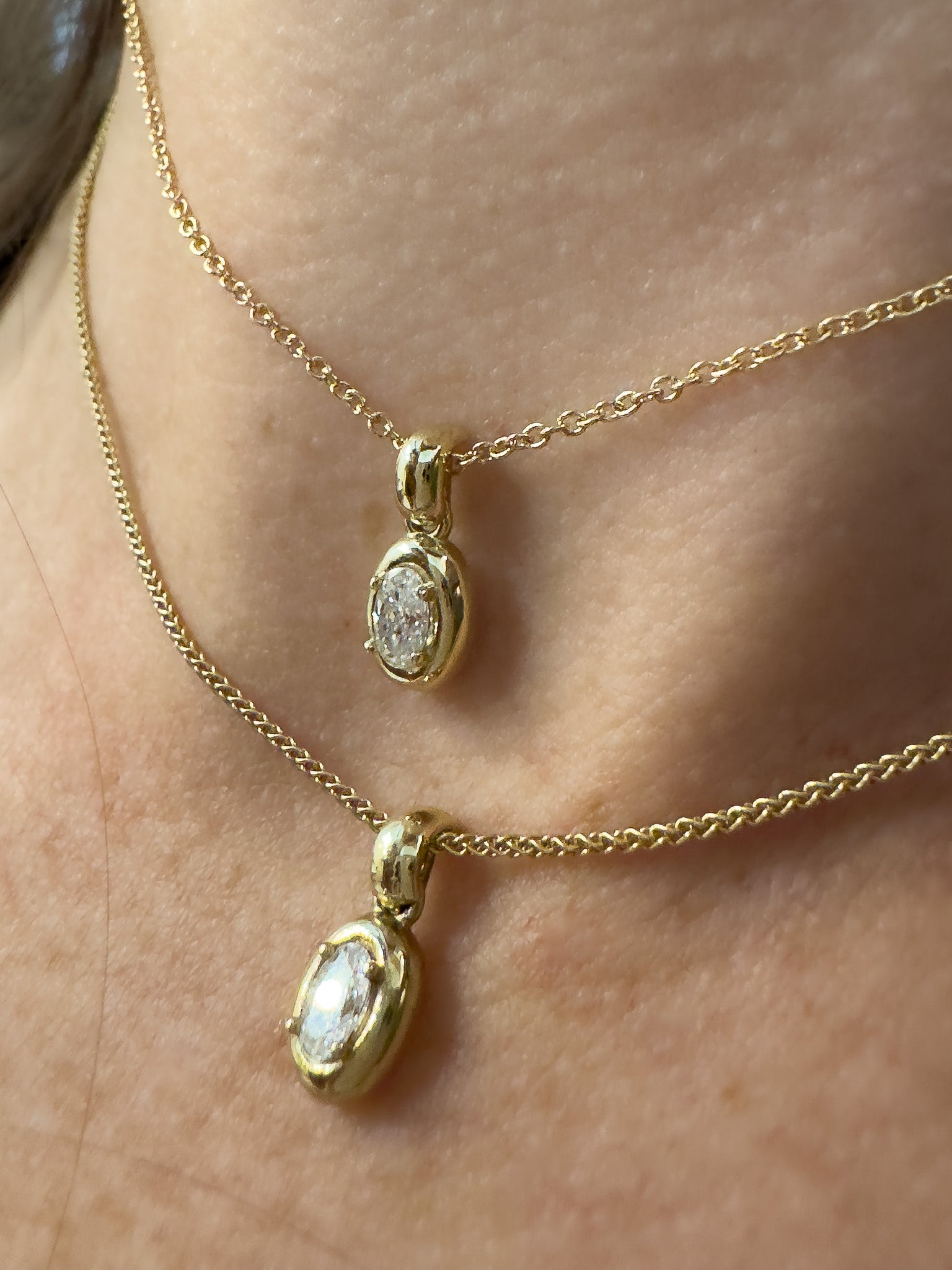 Close-up of a gold necklace with pendant on a person's neck