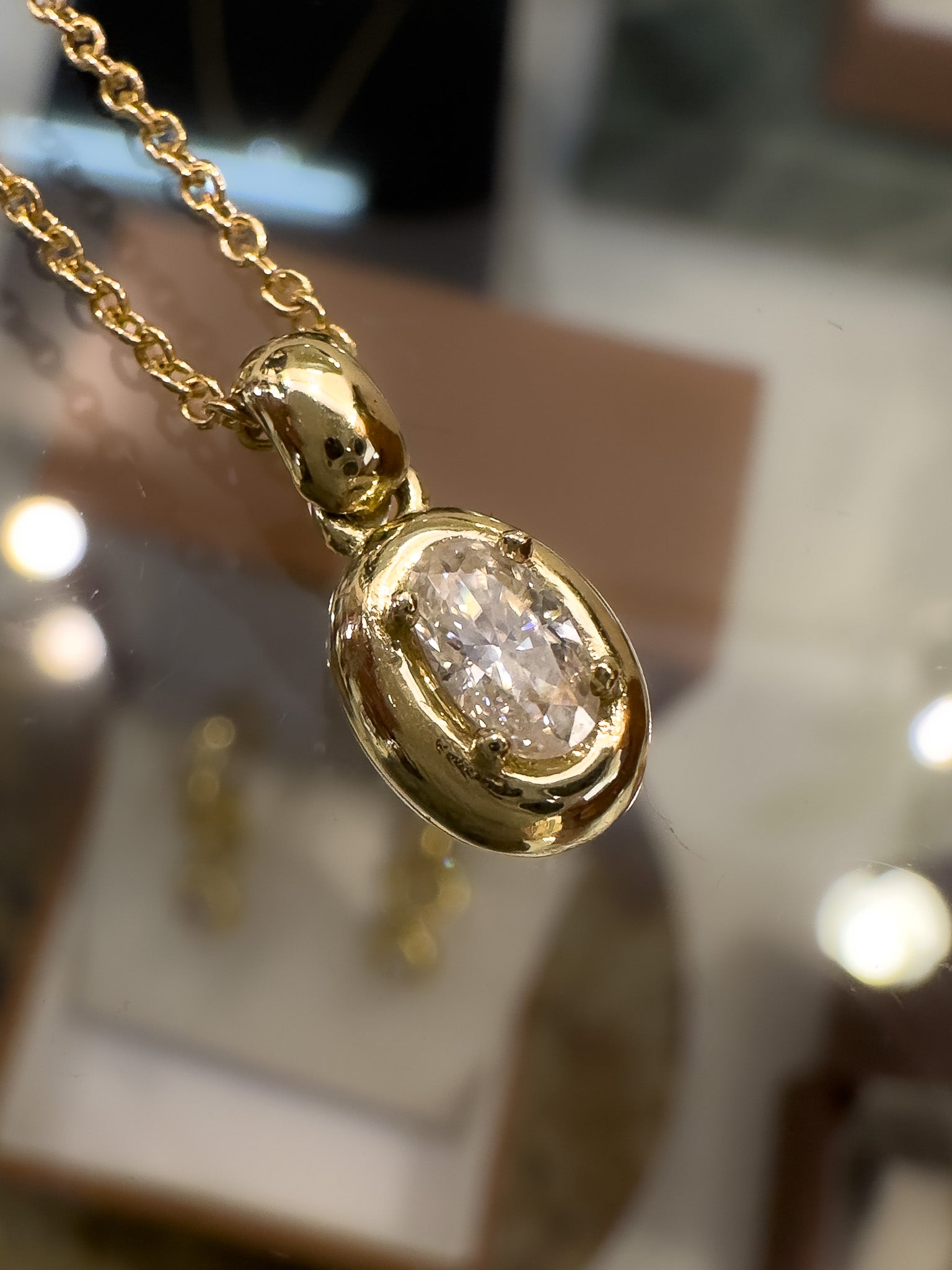 Gold pendant with a diamond on a blurred background