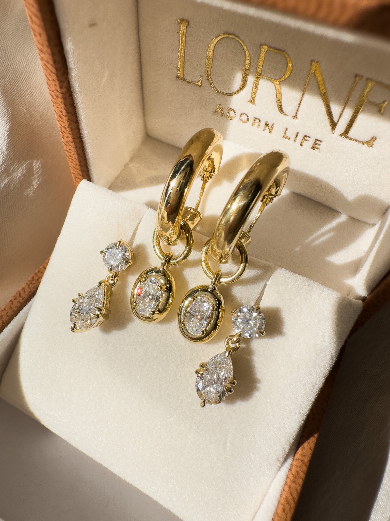 Gold hoop earrings with diamonds on a LORNE branded box.