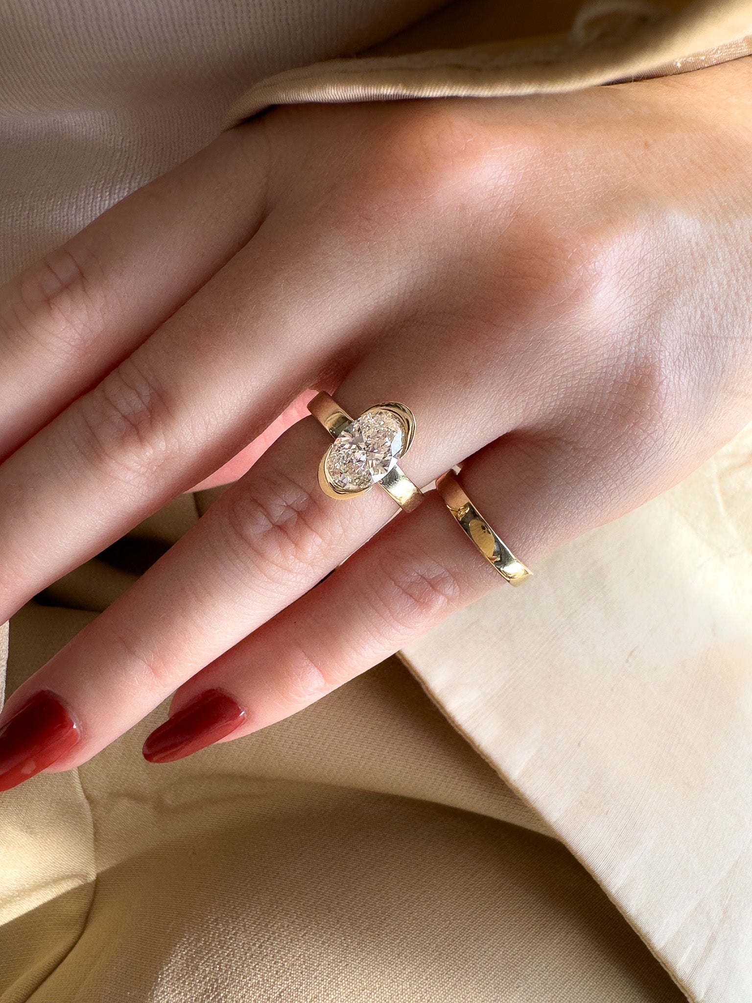 Close-up of a hand wearing two gold rings with a soft background