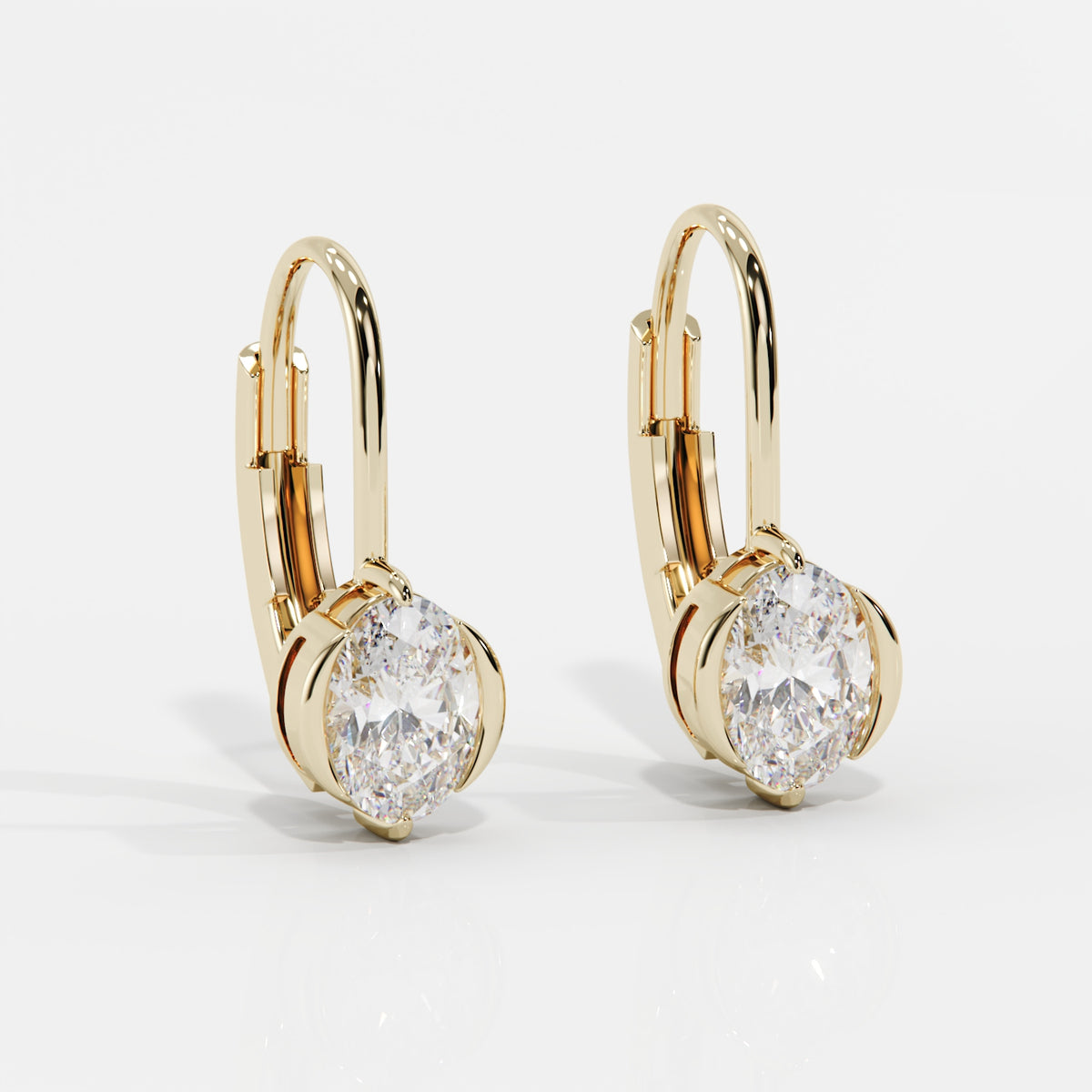 A pair of gold leverback earrings with oval-cut clear gemstones, set against a clean white background.