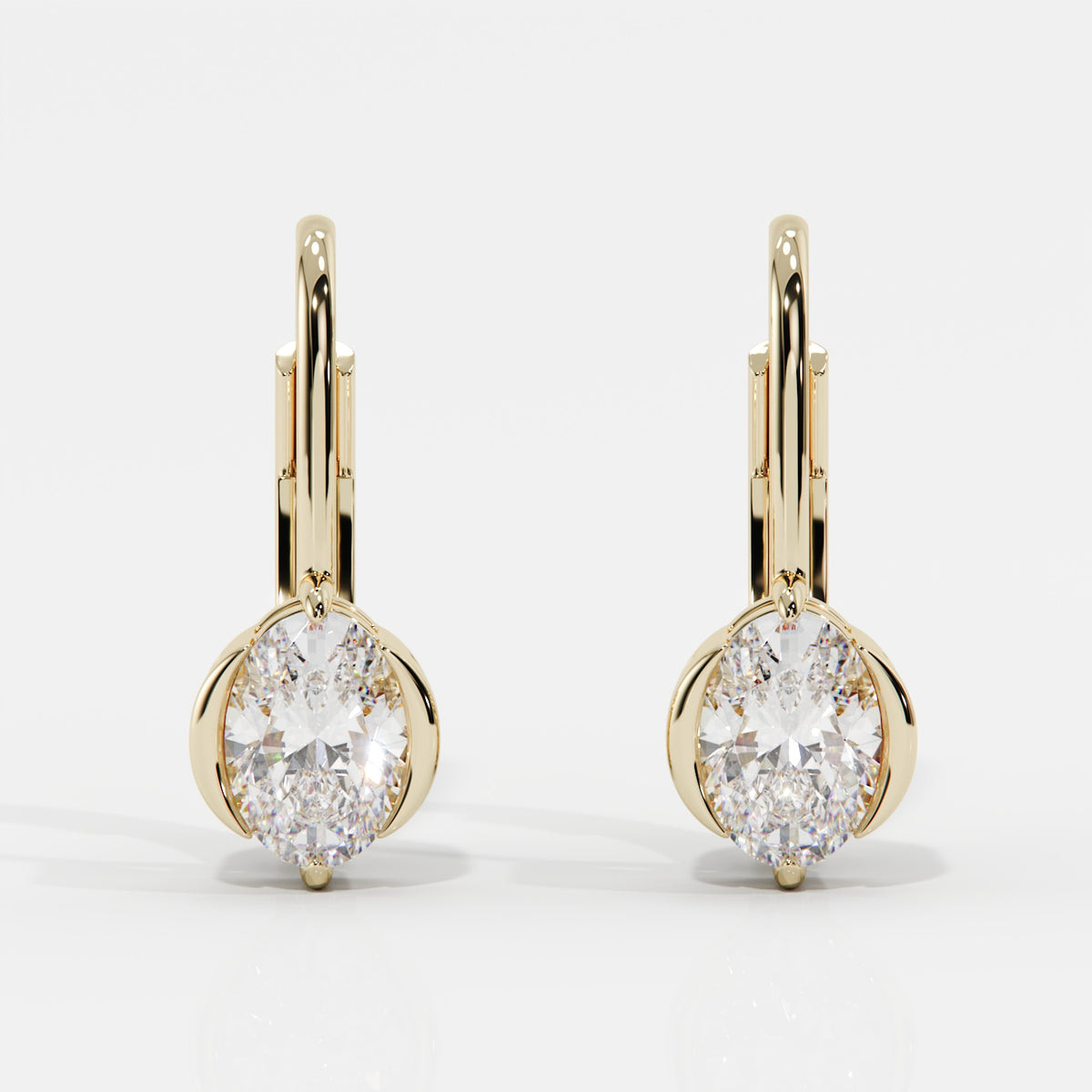 A pair of gold leverback earrings with oval-cut clear gemstones in a prong setting, shown on a clean white background.