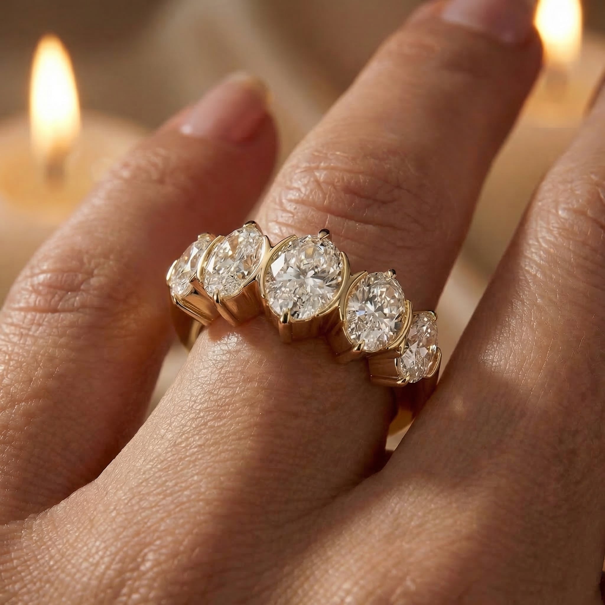Gold ring with diamonds on a hand in front of candles