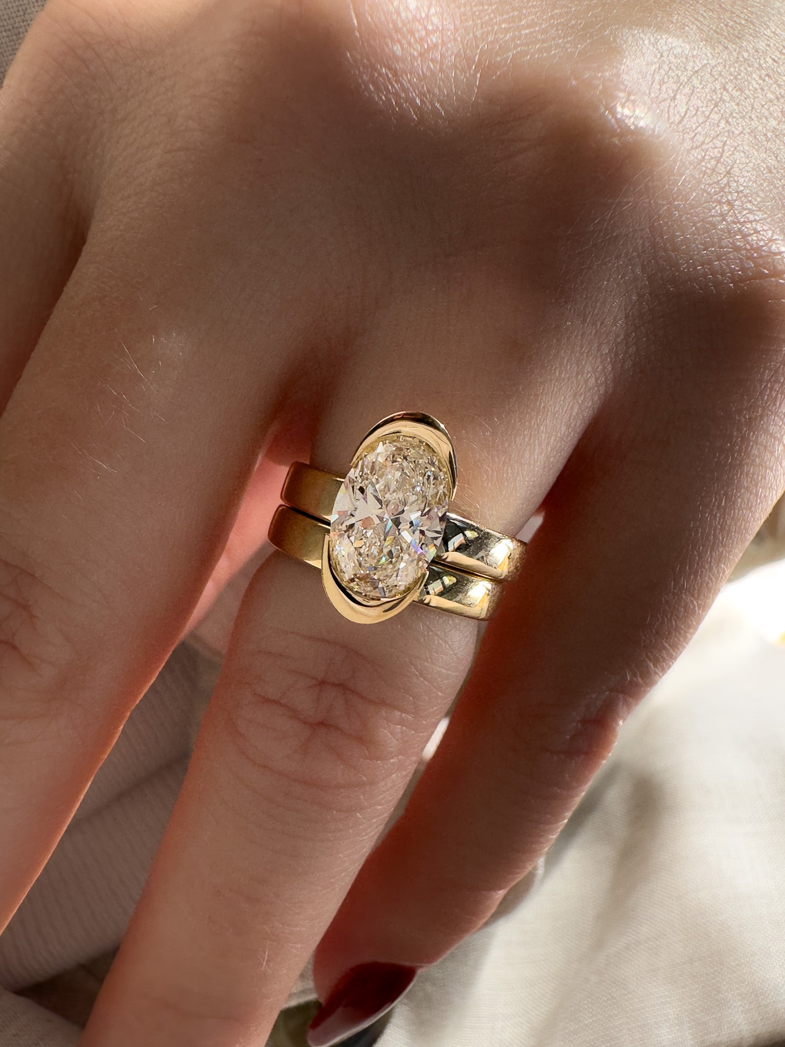 Gold ring with a large diamond on a person's finger