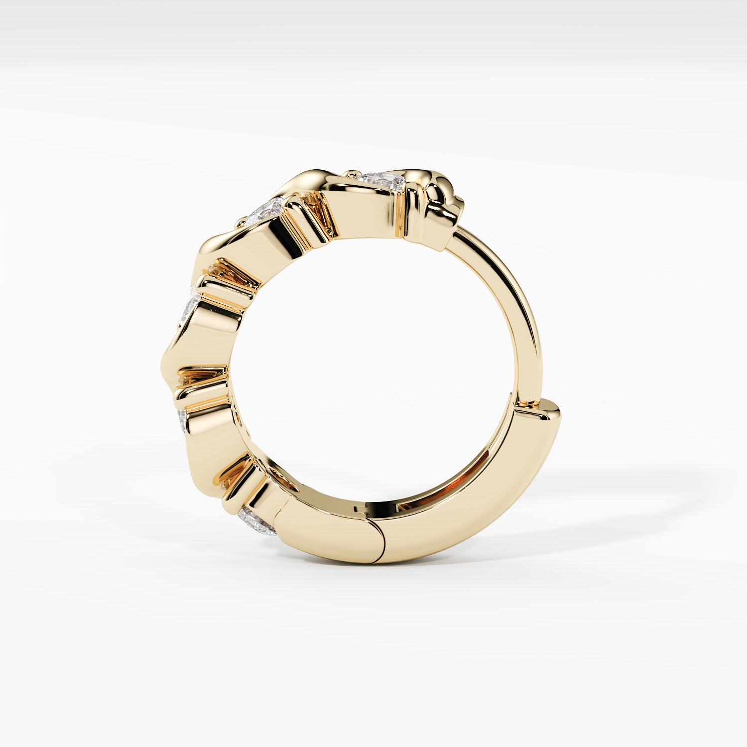 A gold huggie ring with a textured, segmented outer band and small clear gemstones set along the top, shown on a clean white background.