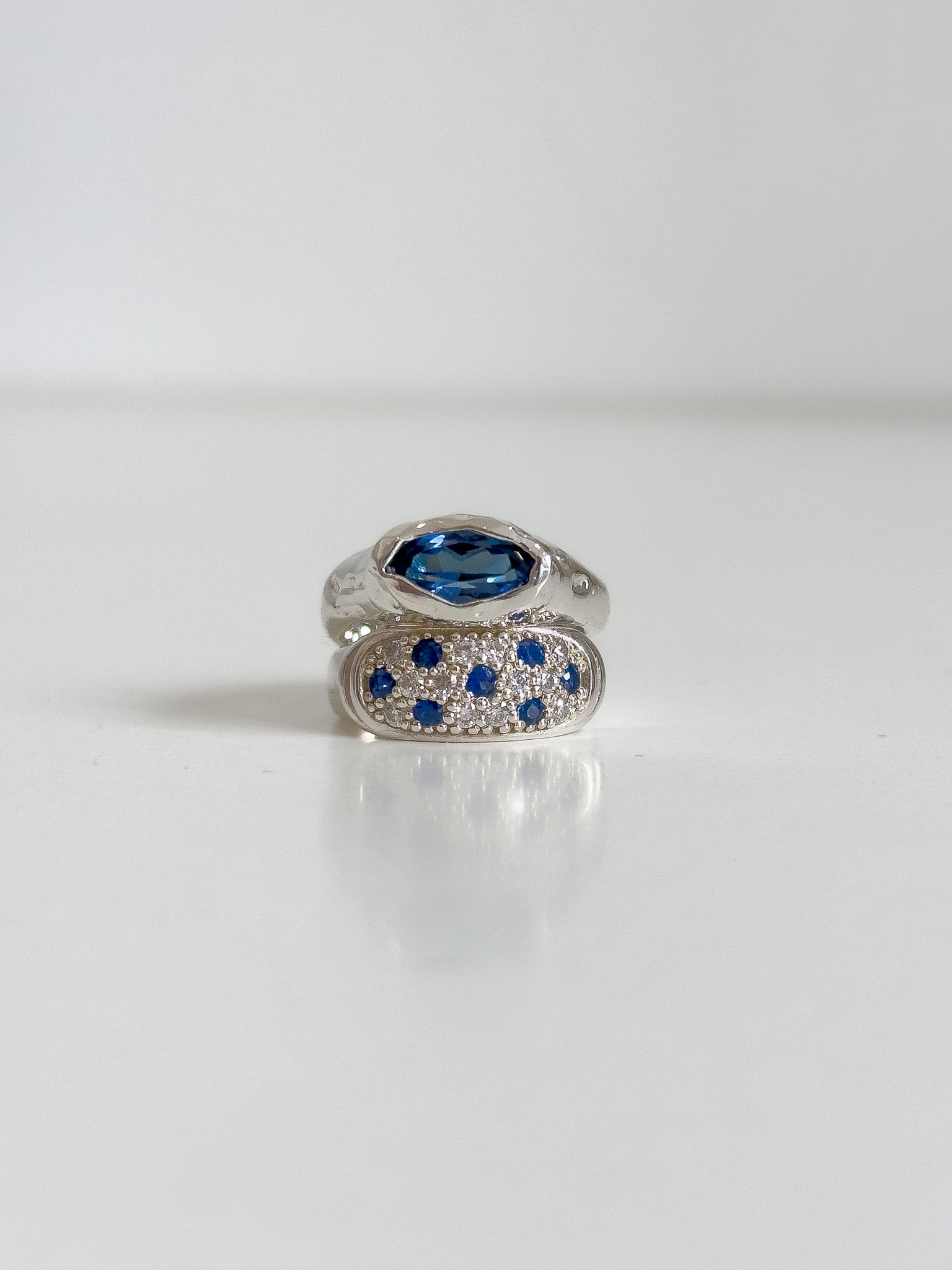 Silver ring with blue gemstones on a white background